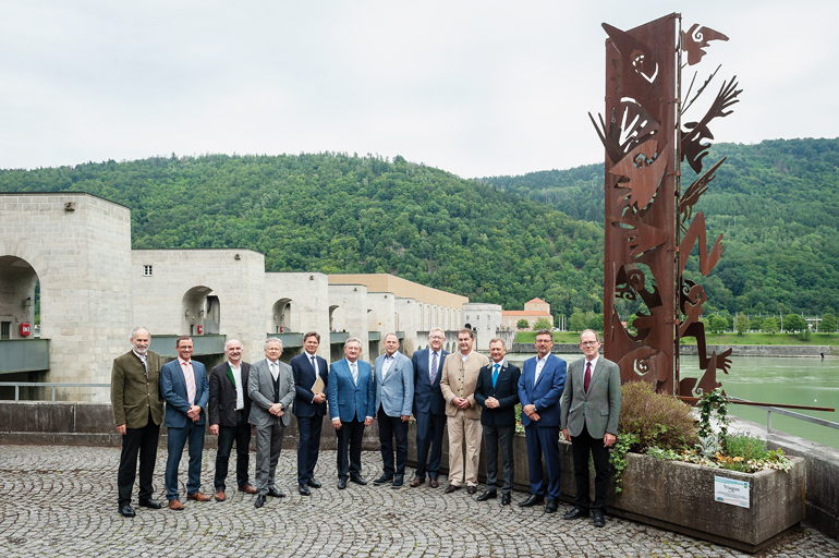 Ehrengäste vor dem Donaukraftwerk Jochenstein – Burg im Strom – mit Skulpturen von Miguel Horn aus Passau.