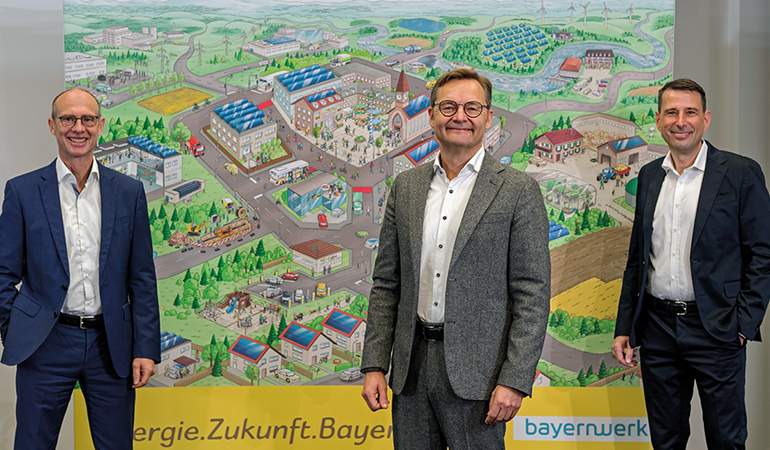 Die Bayernwerk-Vorstände Dr. Egon Leo Westphal, Reimund Gotzel (Vorsitzender) und Andreas Ladda (v.l.) vor der „Flower-Power“-Illustration, die das Energiesystem der Zukunft darstellt. Bild: Uwe Moosburger, altrofoto/Bayernwerk AG