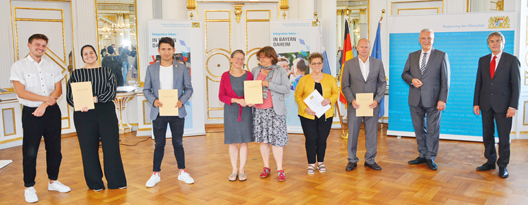 V.l.: Tim Schlierkamp-Voosen und Taqwa Gad vom Verein Migrantenmedizin e.V., Nezamuddin „Karim“ Haydari, Alexandra Geiger und Dr. Esther Burkert vom Verein Hilfe für Geflüchtete und Menschen auf der Flucht Regensburg e.V., Brigitte Ertl, Roland Troidl von der Grund- und Mittelschule Ammersricht, Innen- und Integrationsminister Joachim Herrmann, Regierungspräsident Axel Bartelt, Regierung der Oberpfalz. Bild: Reg. Opf./ Schmied