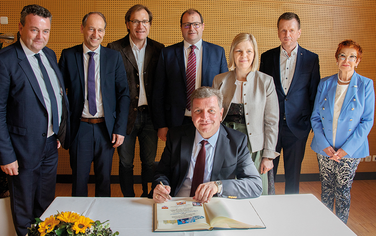 Verkehrsminister Christian Bernreiter trug sich ins Goldene Buch des Marktes Bad Birnbach ein. Stehend dahinter v.l. DB-Regio-Chef Stefan Kühn, MdL Martin Wagle, Bezirkstagsvizepräsident Dr. Thomas Pröckl, Landrat Michael Fahmüller, Bürgermeisterin Dagmar Feicht, Bayerns Bahnchef Klaus-Dieter Josel und Ex-MdL Reserl Sem. Bild: Kurverwaltung Bad Birnbach