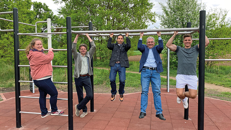 V.l.: Julia Feulner (Umsetzungsbegleiterin der Kommunalen Allianz Biberttal-Dillenberg), Wolfgang Schaffrien (Bauamtsleiter), Oliver Müller (Bauamt), Kurt Krömer (Erster Bürgermeister) und Fitness-Influencer Christian Krömer bei einer kleinen Übung an dem neuen Fitnessgerät. Bild: Stadt Stein