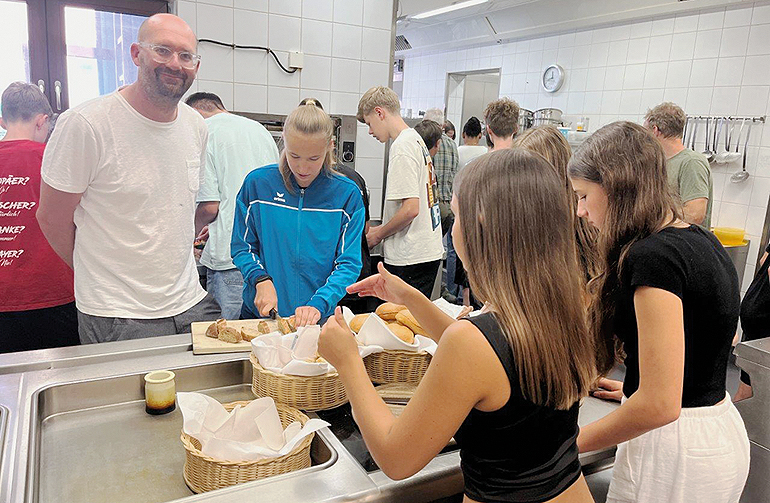 Florian Krommer von der Regionalbewegung mit Schülerinnen und Schülern der 8. Klasse bei der Zubereitung des regionalen Picknicks. Bild: Andrea Winter, Bundesverband der Regionalbewegung e.V.