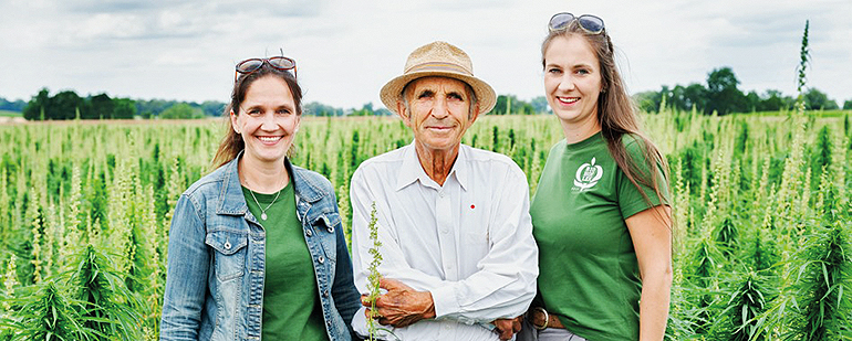 TAGWERK-Landwirtin und ehemalige Biokönigin Raphaela Lex (r.) mit Schwester Bernadette und Papa Lorenz auf ihrem Hanf-Feld. Bild: Being Organic in EU