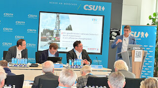 Bild von Personen am Rednerpult