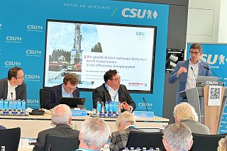 Bild von Personen am Rednerpult