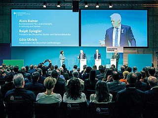 Foto von Redenern am Pult mit Publikum