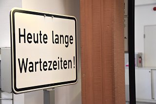Bild eines Schildes mir der Aufschrift "heute lange Wartezeiten"