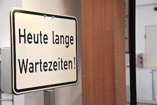 Bild eines Schildes mir der Aufschrift "heute lange Wartezeiten"