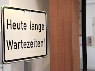 Bild eines Schildes mir der Aufschrift "heute lange Wartezeiten"