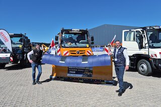 Bild von zwei Personen vor einem Fahrzeug