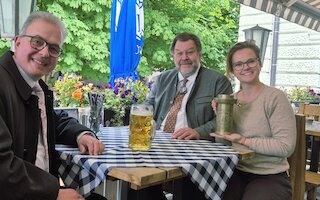 V. l.: Mit einer historischen „Mutter einer bayerischen Maß“ und einem heutigen Maßkrug erinnern Florian Streibl, Fraktionsvorsitzender der Freien Wähler im Bayerischen Landtag, Stefan Thums, Leiter des Bayerischen Landesamts für Maß und Gewicht, und GZ-Verlegerin Theresa von Hassel am Welttag der Metrologie (20. Mai) an die Geschichte des bayerischen Biermaßes. Bild: CH