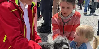Bild von drei Personen und einem Hund