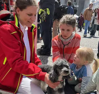 Bild von drei Personen und einem Hund