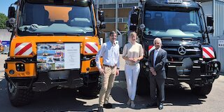 Tim Oßwald, Oberbürgermeisterin Katrin Albsteiger und Prof. Gerhard Mayer vor den neuen Unimog der Stadt Neu-Ulm (l.) und dem Jubiläumsfahrzeug der Firma Wilhelm Mayer. Bild: CH