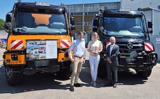Tim Oßwald, Oberbürgermeisterin Katrin Albsteiger und Prof. Gerhard Mayer vor den neuen Unimog der Stadt Neu-Ulm (l.) und dem Jubiläumsfahrzeug der Firma Wilhelm Mayer. Bild: CH