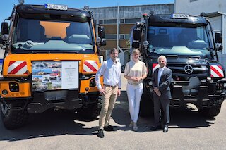 Tim Oßwald, Oberbürgermeisterin Katrin Albsteiger und Prof. Gerhard Mayer vor den neuen Unimog der Stadt Neu-Ulm (l.) und dem Jubiläumsfahrzeug der Firma Wilhelm Mayer. Bild: CH
