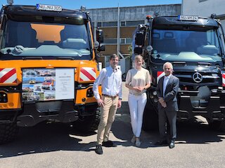 Tim Oßwald, Oberbürgermeisterin Katrin Albsteiger und Prof. Gerhard Mayer vor den neuen Unimog der Stadt Neu-Ulm (l.) und dem Jubiläumsfahrzeug der Firma Wilhelm Mayer. Bild: CH