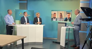 V.l. Bernd Göttlicher (Leiter Kommunalmanagement Franken), Dr. André Zorger (Leiter Kommunalmanagement Ostbayern) und Silke Mall (Leiterin Kommunalmanagement Oberbayern) sowie online zugeschaltet Christian Brunner, 1. Bürgermeister Gemeinde Bindlach, Jonas Höcker, 1. Bürgermeister Stadt Grafenau und Thomas Albrecht, 1. Bürgermeister Gemeinde Krün gemeinsam mit Moderator Tilmann Schöberl. Bild: Sandra Heidrich