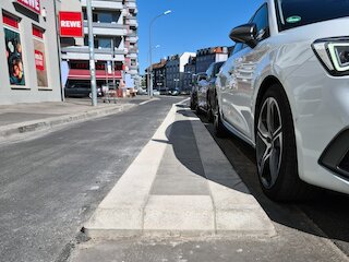 Die Fahrbahntrennung zwischen Fahrradweg und geparkten Autos.