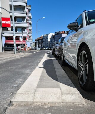 Die Fahrbahntrennung zwischen Fahrradweg und geparkten Autos.